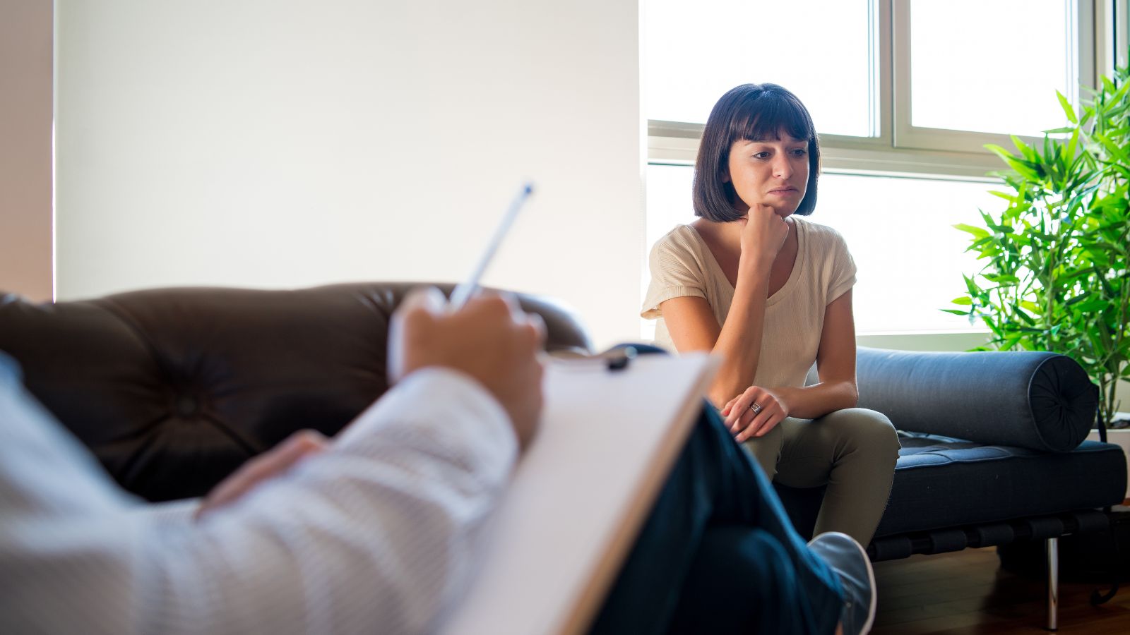Woman in a private autism assessment consultation with a clinician taking notes